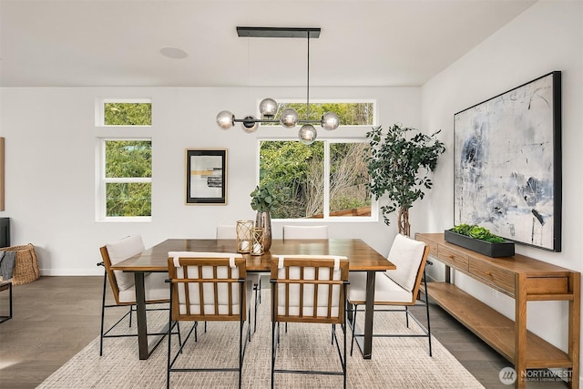 dining area with an inviting chandelier, wood finished floors, and a healthy amount of sunlight