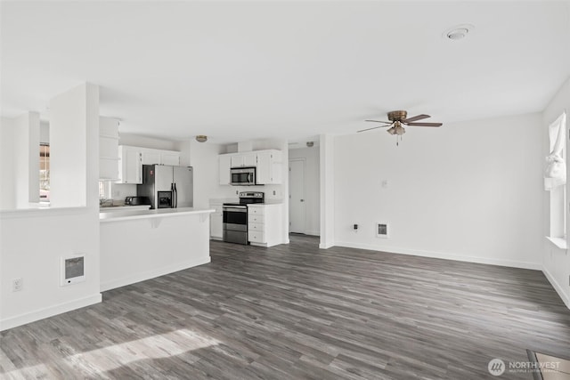 unfurnished living room featuring dark wood finished floors, ceiling fan, and baseboards