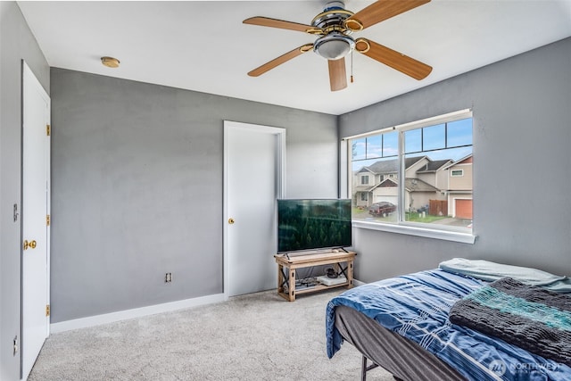 carpeted bedroom with a ceiling fan and baseboards