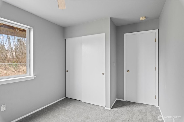 unfurnished bedroom featuring multiple windows, a closet, and carpet floors