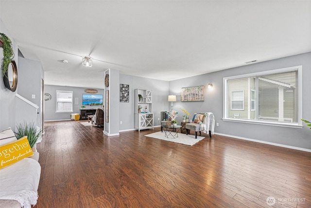 unfurnished living room with visible vents, baseboards, and hardwood / wood-style floors