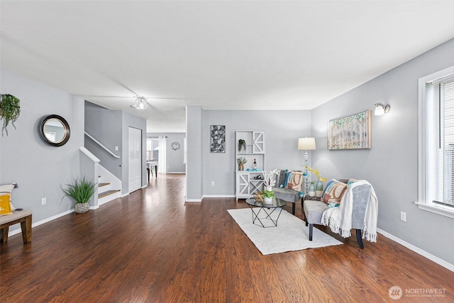 living room with baseboards, plenty of natural light, wood finished floors, and stairs