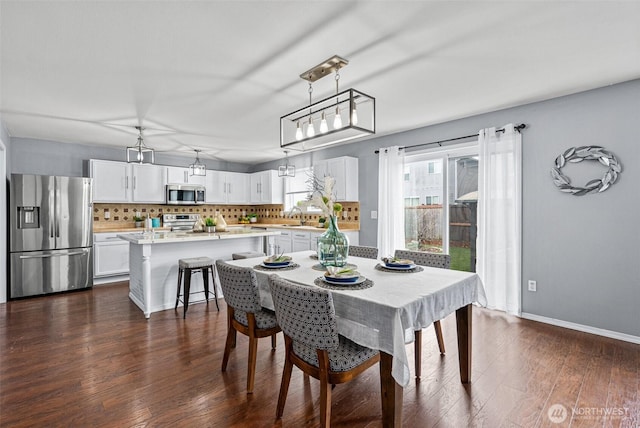 dining area featuring dark wood finished floors and baseboards