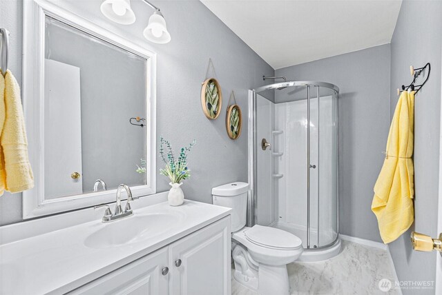 full bath featuring toilet, a stall shower, vanity, and marble finish floor