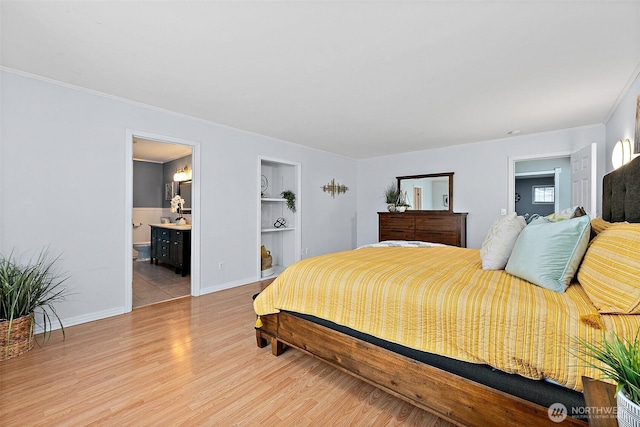 bedroom featuring light wood-style flooring, connected bathroom, baseboards, and ornamental molding