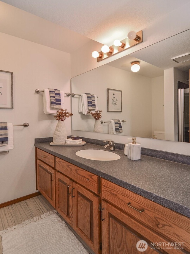 bathroom with visible vents, vanity, and baseboards