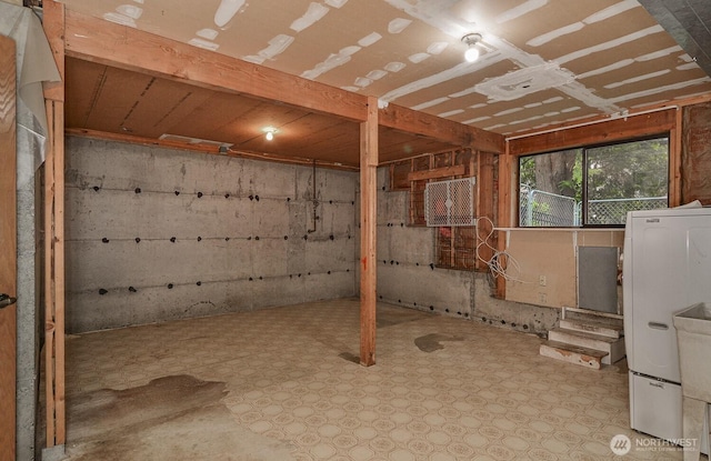 below grade area featuring tile patterned floors and refrigerator