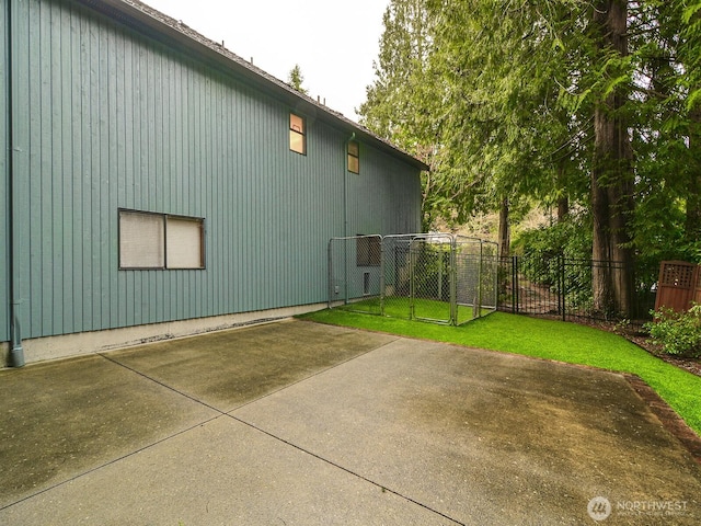 view of side of property featuring a gate, a patio area, a yard, and fence