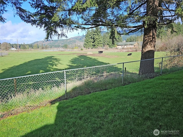 view of yard with a rural view and fence