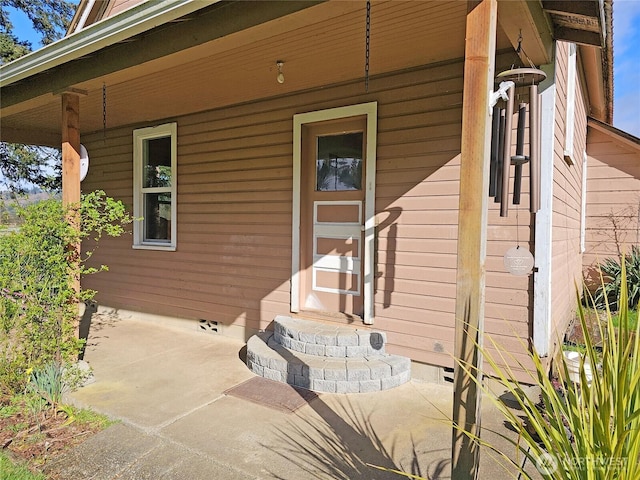 doorway to property featuring a porch and crawl space