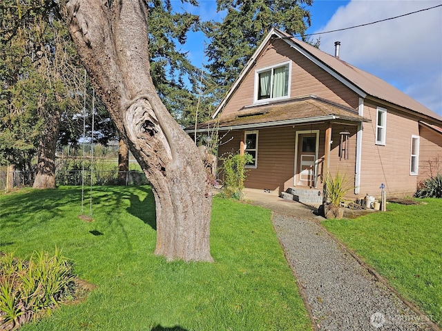 view of front of property featuring a porch, a front yard, and fence