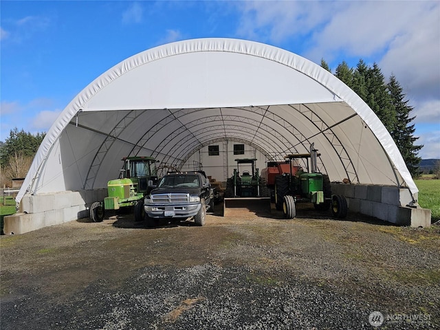 view of parking with a detached carport and an outbuilding