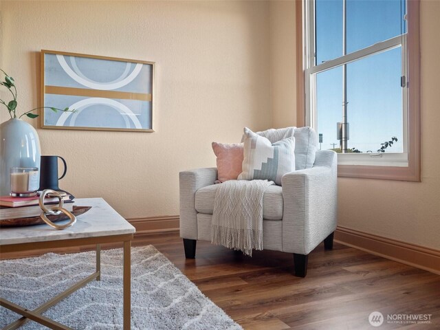 sitting room with baseboards and wood finished floors