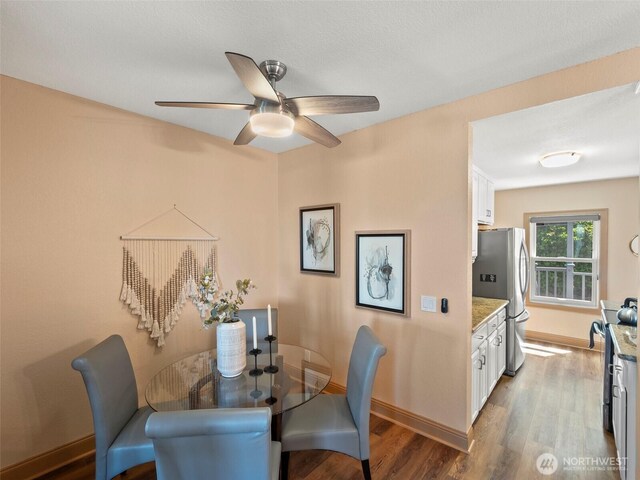 dining area featuring a ceiling fan, wood finished floors, and baseboards