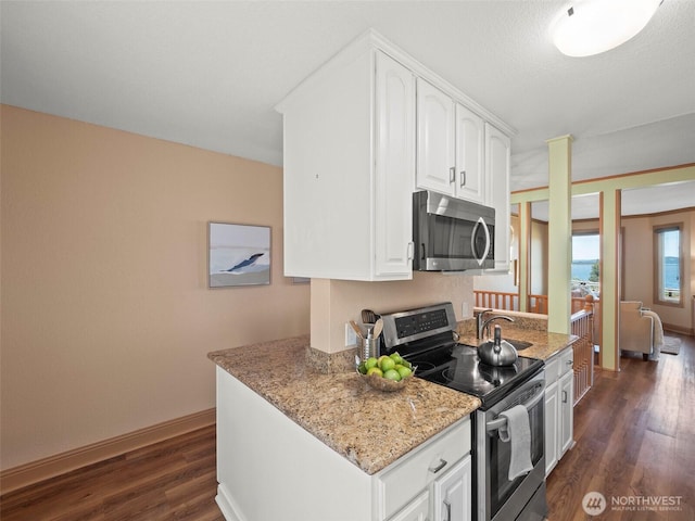 kitchen with light stone countertops, baseboards, dark wood-style flooring, appliances with stainless steel finishes, and white cabinetry