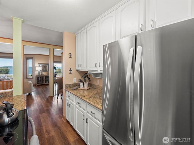 kitchen with dark wood-type flooring, black electric range oven, light stone counters, freestanding refrigerator, and white cabinets