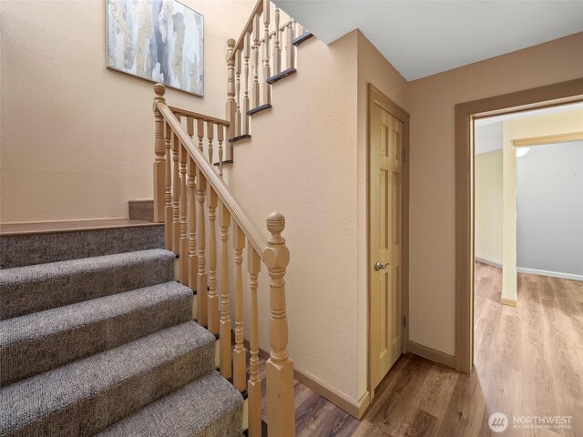 stairway with baseboards and wood finished floors