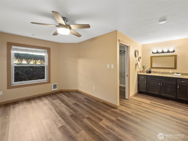 unfurnished bedroom featuring light wood-style floors, visible vents, and baseboards