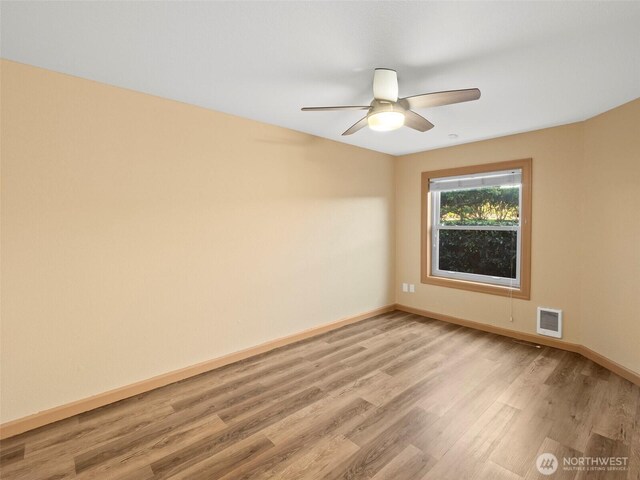 unfurnished room with ceiling fan, visible vents, baseboards, and light wood-style flooring