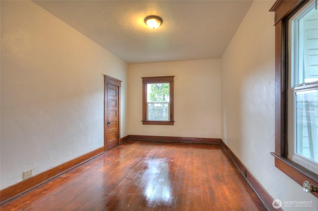 empty room featuring baseboards and wood finished floors