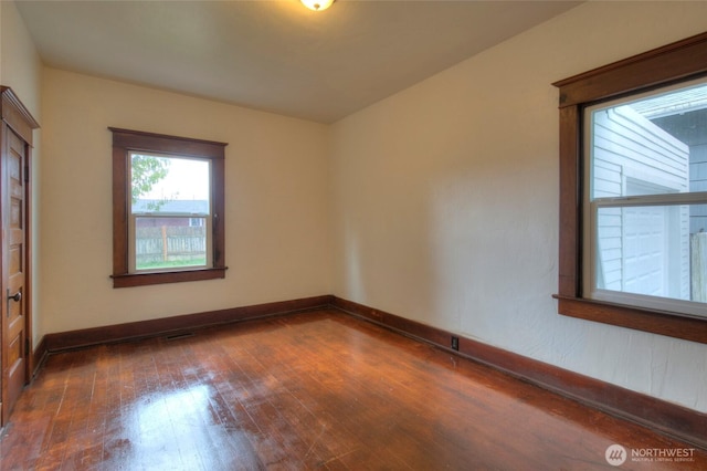 unfurnished room with baseboards and hardwood / wood-style floors