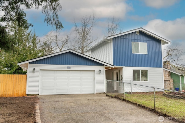 traditional-style house with an attached garage, fence private yard, and concrete driveway