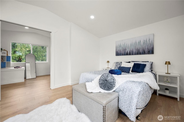 bedroom with vaulted ceiling, recessed lighting, wood finished floors, and baseboards