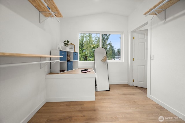 spacious closet featuring light wood-type flooring and lofted ceiling