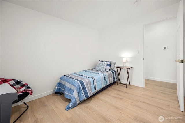 bedroom featuring wood finished floors and baseboards