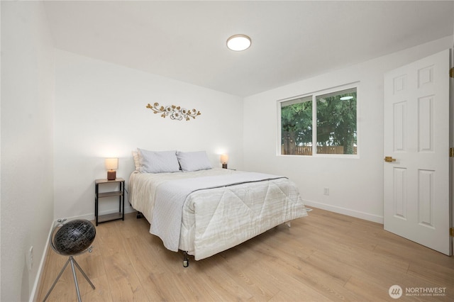 bedroom with baseboards and light wood-type flooring