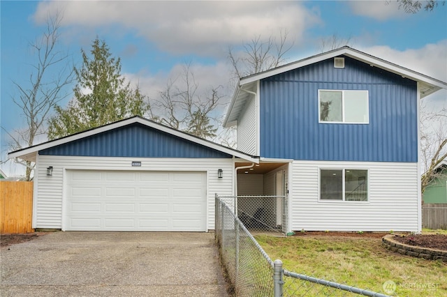 traditional-style house featuring an attached garage, driveway, a front yard, and fence