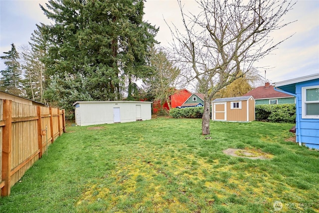 view of yard with a storage unit, an outdoor structure, and fence