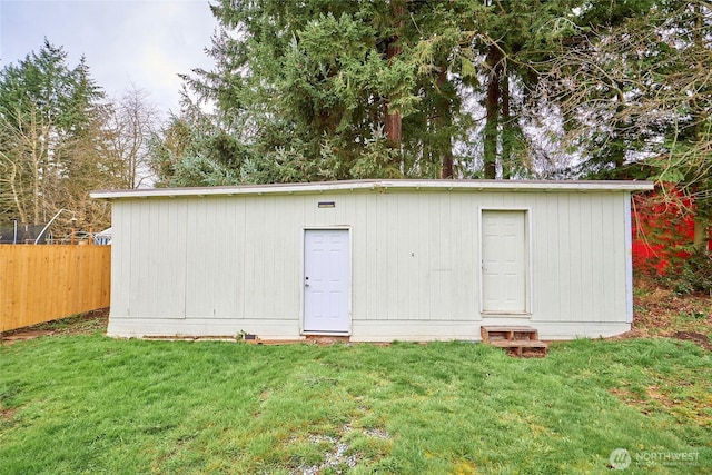 view of outdoor structure featuring an outbuilding and fence