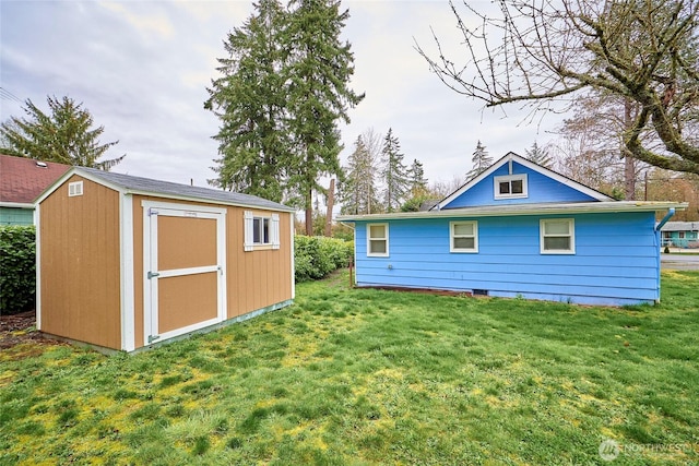 rear view of house featuring a storage shed, an outdoor structure, and a lawn