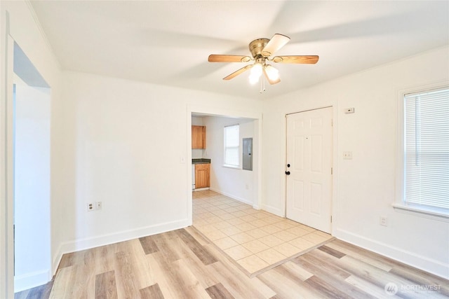 entrance foyer featuring light wood-style flooring, electric panel, a ceiling fan, and baseboards