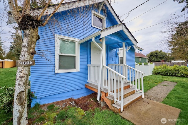 view of front of house featuring a front lawn and fence