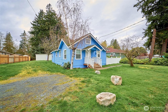 bungalow-style home featuring a front yard and fence