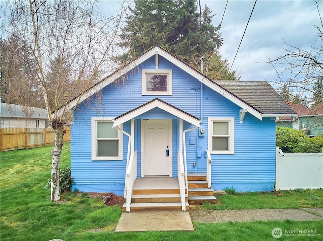 bungalow-style house featuring a front yard and fence