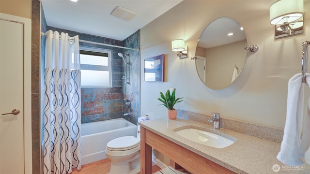 full bath with toilet, shower / bath combo with shower curtain, and vanity