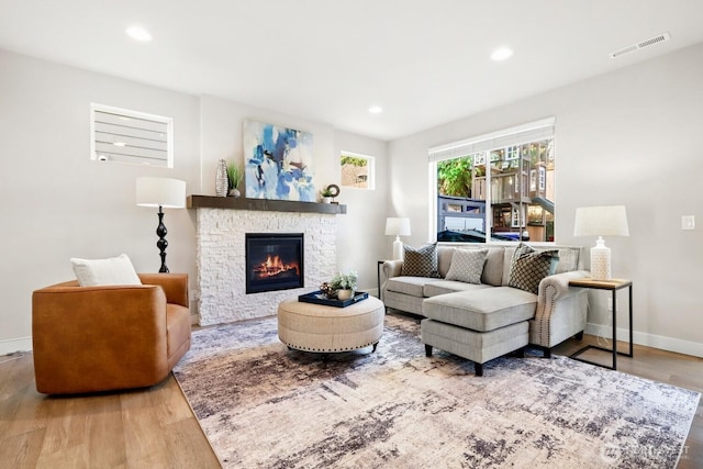 living area with visible vents, wood finished floors, recessed lighting, a fireplace, and baseboards