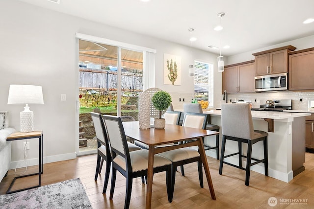 dining area featuring recessed lighting, baseboards, and light wood-style floors