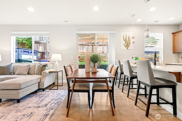 dining room with recessed lighting, a healthy amount of sunlight, visible vents, and light wood finished floors