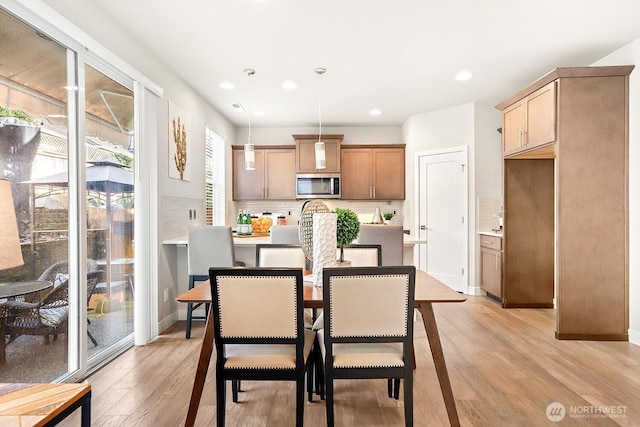 dining space with recessed lighting, baseboards, and light wood-style floors