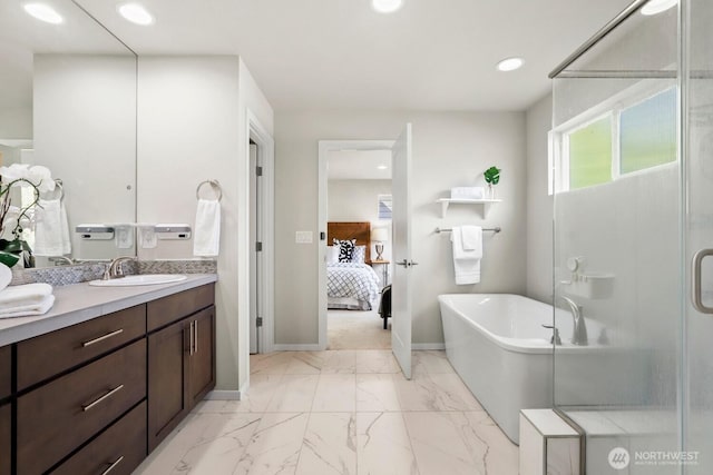 ensuite bathroom with marble finish floor, a stall shower, recessed lighting, a freestanding bath, and vanity