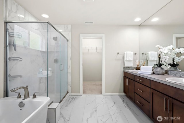 bathroom with double vanity, a stall shower, marble finish floor, and a freestanding bath