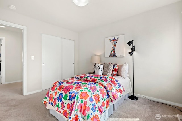 carpeted bedroom with a closet and baseboards