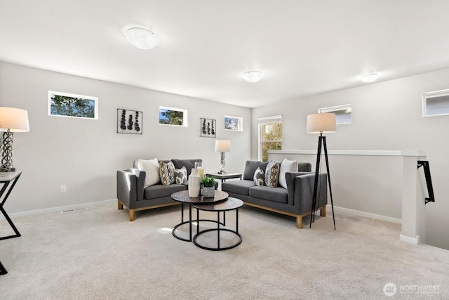 carpeted living area with a healthy amount of sunlight and baseboards