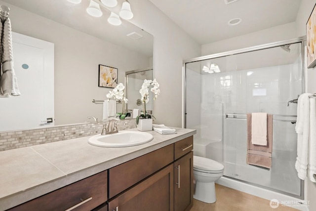 bathroom with tasteful backsplash, visible vents, toilet, a stall shower, and vanity