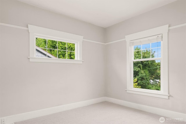 unfurnished room with light carpet and baseboards