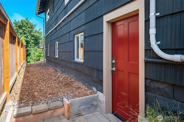 doorway to property featuring fence